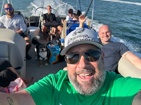 A lively group enjoys a day on the water aboard a boat, capturing fun moments with friends and a dog — perfect for memorable outings and adventures.