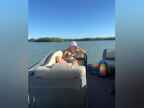 A woman relaxes on the lounge seating of a boat, enjoying the serene waters and sunshine — perfect for a day of leisure on the water.