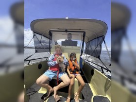 A fun family moment on a boat with kids and a dog, showcasing the joy of on-water adventures together.