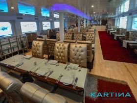 Elegant interior of a dining area on a boat, featuring plush seating and well-set tables, perfect for onboard dining experiences.