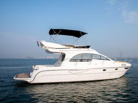 A sleek yacht is docked in calm waters, showcasing its elegant design against a clear blue sky — perfect for luxury boating experiences.