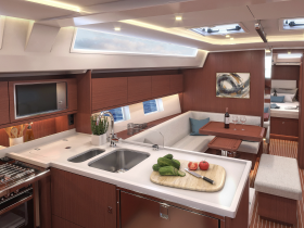 A beautifully designed interior of a yacht featuring a modern kitchen and dining area, perfect for enjoying meals while at sea.