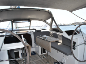 Interior view of a modern yacht's helm and seating area, showcasing a spacious and comfortable design ideal for navigation and relaxation on the water.