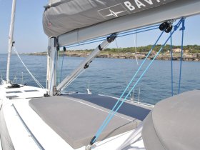 A close-up view of a sleek sailboat's deck, showcasing its modern design and tranquil waters in the background — perfect for sailing enthusiasts.