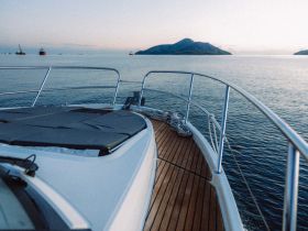 A serene view from the front of a yacht, showcasing the calm waters and distant islands, perfect for a peaceful boating experience.