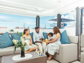 A family enjoys quality time together inside a stylish boat cabin, surrounded by comfortable seating and beautiful views — perfect for relaxation on the water.
