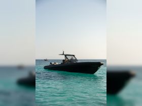 A sleek speedboat glides through crystal-clear waters, showcasing its elegant design and perfect for thrilling adventures on the sea.
