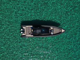 A stunning aerial view of a sleek speedboat gliding over crystal-clear turquoise waters, showcasing the beauty of a perfect day on the water.