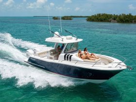 A group enjoys a sunny day on a boat, relaxing and sunbathing while cruising through clear turquoise waters — perfect for summer adventures.