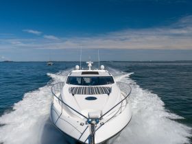 A striking view of a sleek yacht cruising through calm waters, showcasing its elegant design and powerful performance.