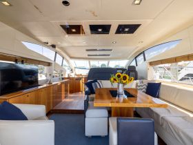 A beautifully designed interior of a yacht featuring a spacious dining area and comfortable seating, perfect for relaxing and entertaining while on the water.