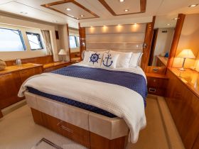 A beautifully designed boat cabin featuring a cozy bedroom with nautical decor, perfect for relaxing on the water.