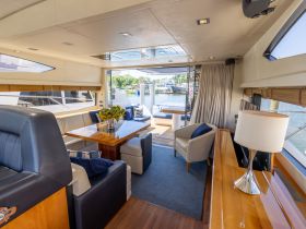 Interior view of a luxurious boat cabin featuring a spacious dining area and comfortable seating, perfect for relaxing and entertaining while on the water.