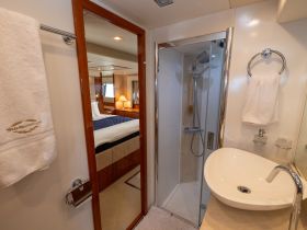A well-appointed bathroom inside a luxury yacht, featuring a modern shower and elegant sink, perfect for onboard comfort.