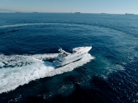 A stunning aerial view of a yacht cruising through deep blue waters, showcasing the elegance of boating on the open sea.
