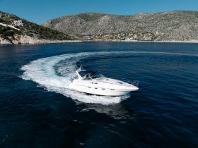 A sleek speedboat navigates through clear blue waters, showcasing its elegant design and agility while underway.