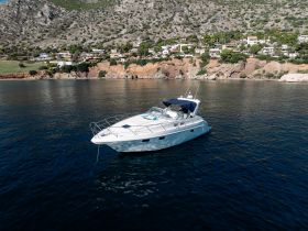 A stunning aerial view of a sleek speedboat anchored in calm waters, surrounded by picturesque coastal scenery — perfect for exploring hidden gems along the shoreline.