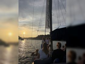 A group of friends enjoys a beautiful sunset aboard a yacht, capturing memories and celebrating together on the water.