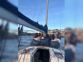 A group of friends enjoys a sailing experience, relaxing on the deck of a yacht while taking in the scenic views — perfect for memorable boat tours and celebrations.