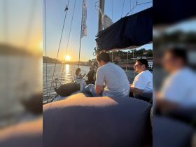 A group enjoys a beautiful sunset while sailing, creating a perfect atmosphere for relaxation and celebration on the water.