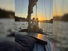 A lively group enjoys a sunset sailing experience, capturing the joy of friendship and celebration on the water.