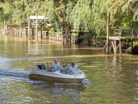 A joyful group enjoys a leisurely boat ride on the river, capturing the essence of family fun and outdoor adventure.