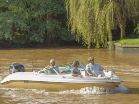 A group of friends enjoys a leisurely ride on a boat through scenic waters, perfect for a day of adventure and relaxation.