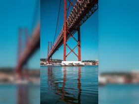 A view of a bridge reflecting in the water, with unclear details and no identifiable subjects.