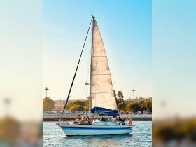 A lively group enjoys a sailing experience aboard a beautiful sailboat, gliding through calm waters — perfect for memorable outings on the sea.