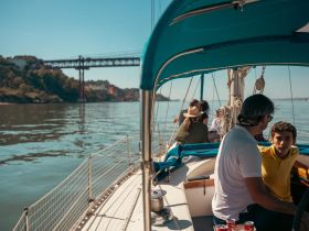 A family enjoys a sailing trip, engaging in conversation while taking in the scenic views — a perfect way to bond on the water.