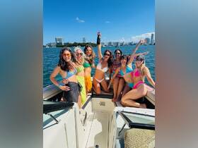 A lively group of friends celebrates on a boat, raising champagne in a fun-filled bachelorette party atmosphere — perfect for unforgettable moments on the water.
