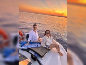 Two friends enjoy a beautiful sunset aboard a boat, capturing the essence of relaxation and celebration on the water.