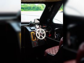 A detailed view of the helm and console area inside a boat, showcasing the steering wheel and various controls, perfect for navigating the waters.