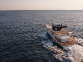 A stunning yacht named 'Yalou Treasure' cruising through calm waters, showcasing its sleek design and elegance on the open sea.