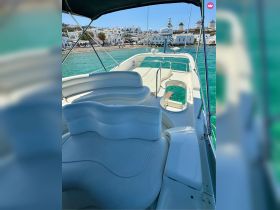 A spacious and stylish interior view of a boat's seating area, showcasing comfortable seating and a helm, perfect for relaxing while enjoying the scenic waters.