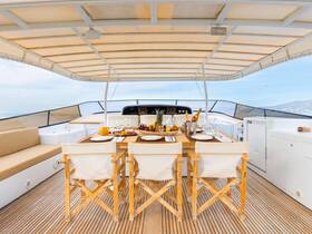An elegant dining area on a yacht featuring a beautifully arranged table with food and drinks, perfect for luxurious onboard meals and gatherings.