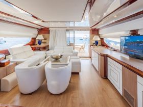 A beautifully designed interior of a yacht featuring a spacious lounge area with comfortable seating and a view of the water, perfect for relaxing during a luxurious boating experience.