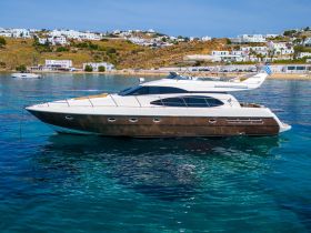 A stunning yacht anchored in crystal-clear waters, showcasing its sleek design against a picturesque coastal backdrop.