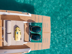 An aerial view of a luxurious boat deck featuring a yellow jet ski and spacious seating area, perfect for water adventures and relaxation under the sun.
