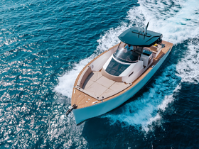 A stunning aerial view of a sleek speedboat cruising through sparkling turquoise waters, showcasing its modern design and elegance.
