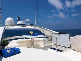 A beautifully arranged lounge area on a yacht, featuring a table set with drinks and towels, perfect for relaxing on the water.