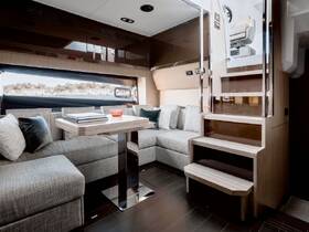 A stylish interior view of a boat's cabin featuring comfortable seating and a dining area, perfect for relaxing and entertaining while on the water.