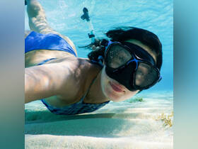 A snorkeler captures a selfie underwater, showcasing the vibrant aquatic environment — a perfect moment for adventure seekers exploring marine life.