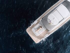 An aerial view of a luxurious yacht with a person sunbathing on the deck, showcasing the perfect setting for relaxation and leisure on the water.