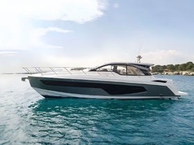 A sleek yacht glides through clear waters, showcasing its modern design and elegance — perfect for luxury cruising.