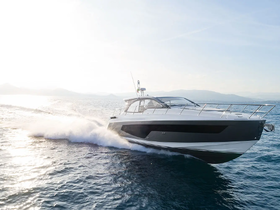 A sleek speedboat cuts through the water, showcasing its elegant design and performance on a sunny day.