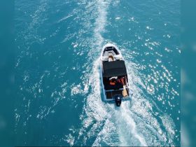 An aerial view of a boat cruising through sparkling turquoise waters, showcasing the excitement of a day on the water.