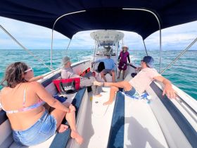 A group of friends relaxes on a boat, enjoying the beautiful ocean views — perfect for a day of fun and adventure on the water.
