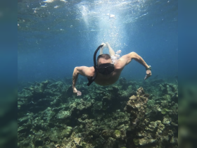A snorkeler explores vibrant underwater scenery, showcasing the beauty of marine life and coral formations — an unforgettable adventure in the ocean.