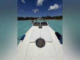 A person enjoys the stunning turquoise waters while standing on the bow of a boat, surrounded by a tropical paradise — perfect for adventure seekers and beach lovers.